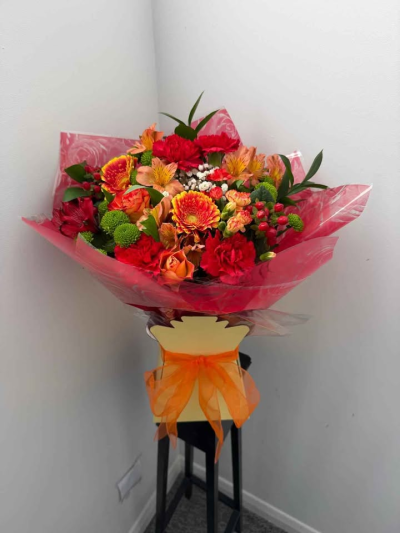 Fiery Sunset Hand-Tied - A striking hand-tied bouquet inspired by warm, glowing sunset tones. Bursting with rich colour and lively textures, this arrangement creates a bold and uplifting display, beautifully wrapped and finished with a coordinating ribbon.

Perfect for celebrations, special occasions, or making a vibrant statement, this bouquet is full of warmth, energy, and eye-catching charm.