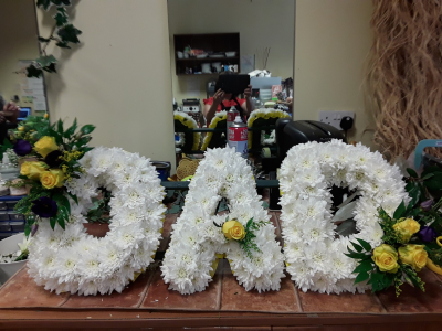 Letters - A heartfelt personalised funeral tribute in elegant white styling with delicate accent details throughout. This meaningful arrangement is a loving way to honour your loved one, offering a touching symbol of remembrance, love, and everlasting devotion.