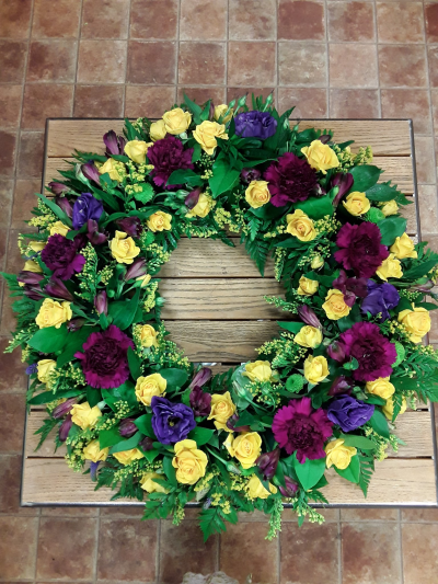 Wreath - A vibrant circular tribute featuring rich golden, deep plum, and soft purple tones nestled within lush greenery. Symbolising remembrance, warmth, and everlasting love, this elegant funeral wreath offers a beautiful and comforting farewell to someone dearly missed.

Can be made