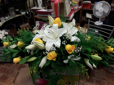 Oasis Spray - A graceful funeral casket spray featuring elegant ivory and golden tones arranged amongst flowing greenery. Designed to offer a heartfelt farewell, this beautiful tribute symbolises peace, love, and treasured memories, creating a dignified and comforting display in honour of a loved one.